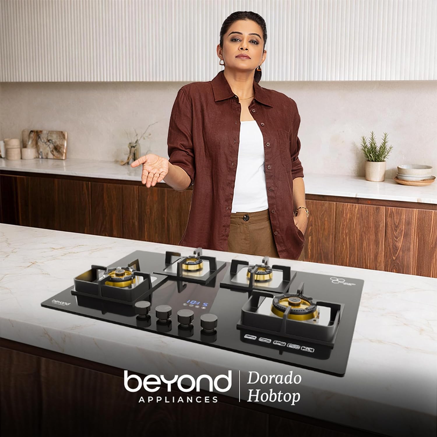 Toughened glass top with a smart timer display. Four brass burners in two sizes, black pan supports and a Toughened Glass badge, with a digital 10:15 display, touch controls, four black knobs and a row of touch icons. Two burners are lit with blue flames to show the brass burner rings in use. The glass surface is easy to wipe clean.